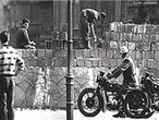Berlim, 13 de agosto de 1961. Em questo de horas, uma barreira passou a dividir os setores leste e oeste da cidade. Nascia o que ficou conhecido como Muro de Berlim. Nesse dia a populao de Berlim foi despertada por barulhos estranhos, exagerados. Ao abrirem suas janelas, depararam-se com um inusitado movimento nas ruas a sua frente. Vrios Vopos, os milicianos da RDA (Repblica Democrtica da Alemanha), a Alemanha comunista, acompanhados por patrulhas armadas, estendiam de um poste a outro um interminvel arame farpado que alongou-se, nos meses seguintes, por 37 quilmetros adentro da zona residencial da cidade. Enquanto isso, atrs deles, trabalhadores desembarcavam dos caminhes descarregando tijolos, blocos de concreto e sacos de cimento. Ao tempo em que algum deles feriam o duro solo com picaretas e britadeiras, outros comeavam a preparar a argamassa. Assim, do nada, comeou a brotar um muro, o Mauer, como o chamavam os alemes. </br></br> Palavras-chave: Muro de Berlim. Alemanha. Comunismo. RDA. Guerra Fria. 